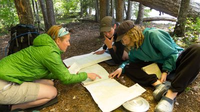 An instructor teaches students a lesson on maps in the backcountry of the Pacific Northwest. 